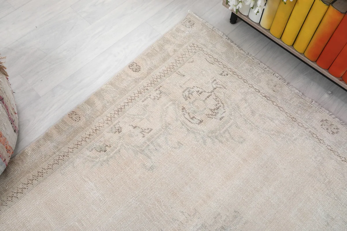 Close-up of a rug corner, revealing the aged look of the border and the muted patterns.