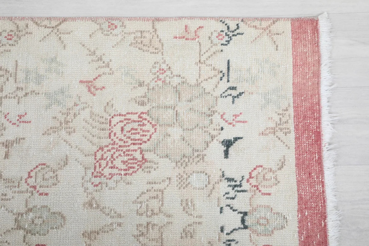 Detailed view of the rug's floral motifs and border, highlighting the hand-knotted texture.