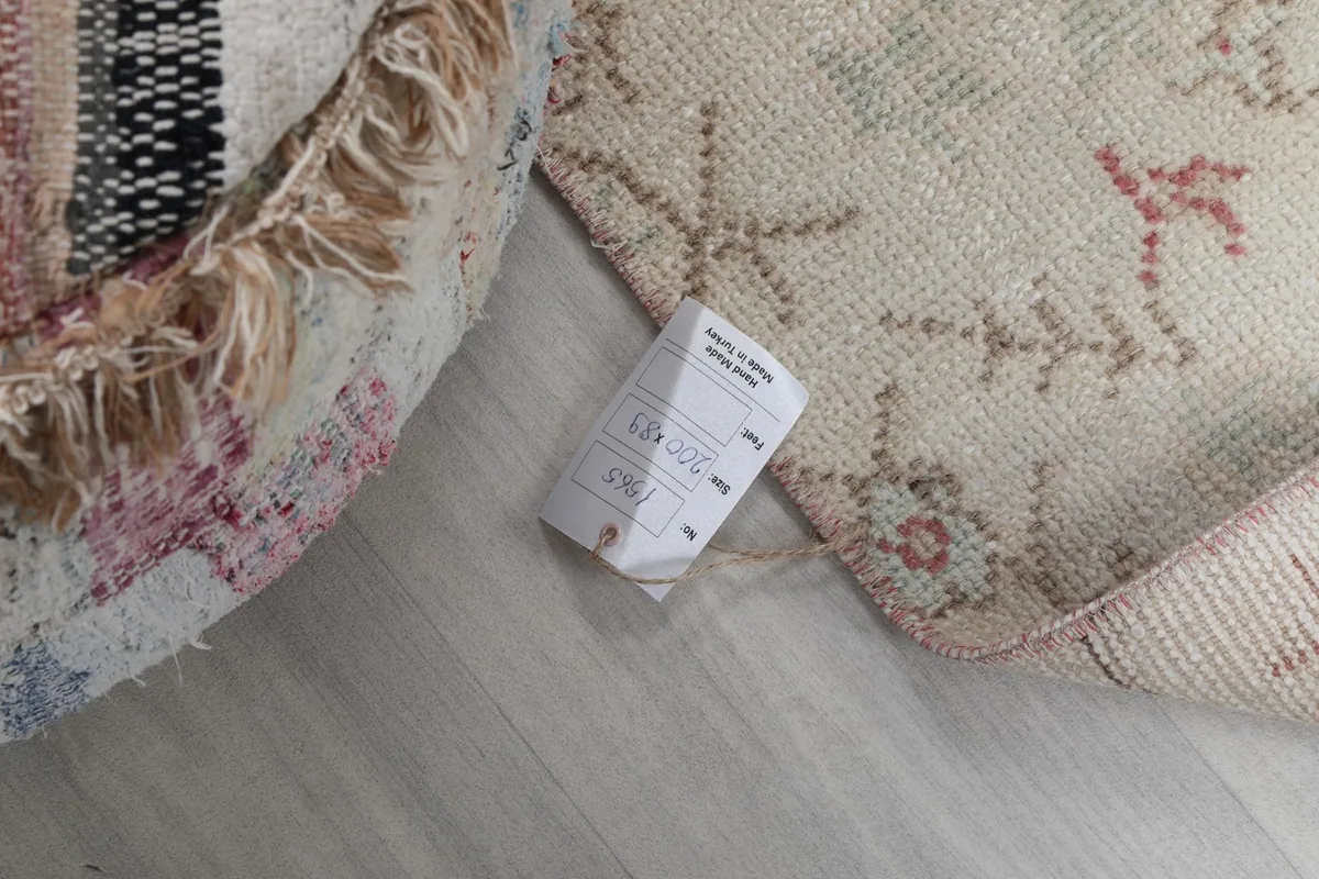 Close-up of the rug's back and a product tag, indicating its origin and material.