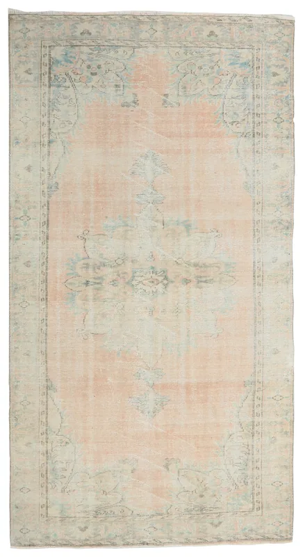 Full overhead view of the vintage pink and blue Anatolian rug on a white background.