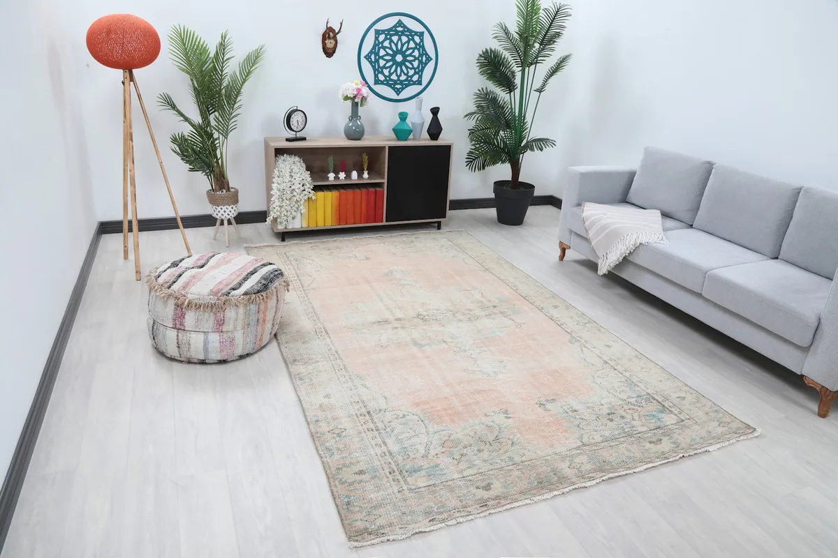 Full view of the pink and blue vintage rug in a modern living space with light colored furniture.