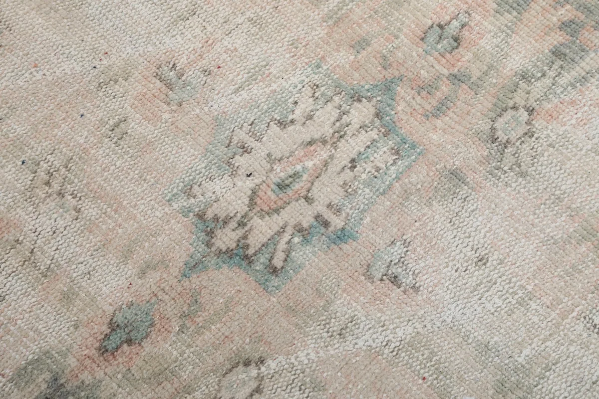 Close-up of a specific floral motif in blue and pink tones, showing the low pile.