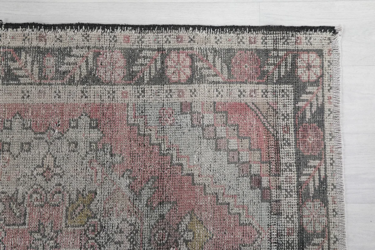 Detailed view of the upper right corner, highlighting the geometric border and faded rose field