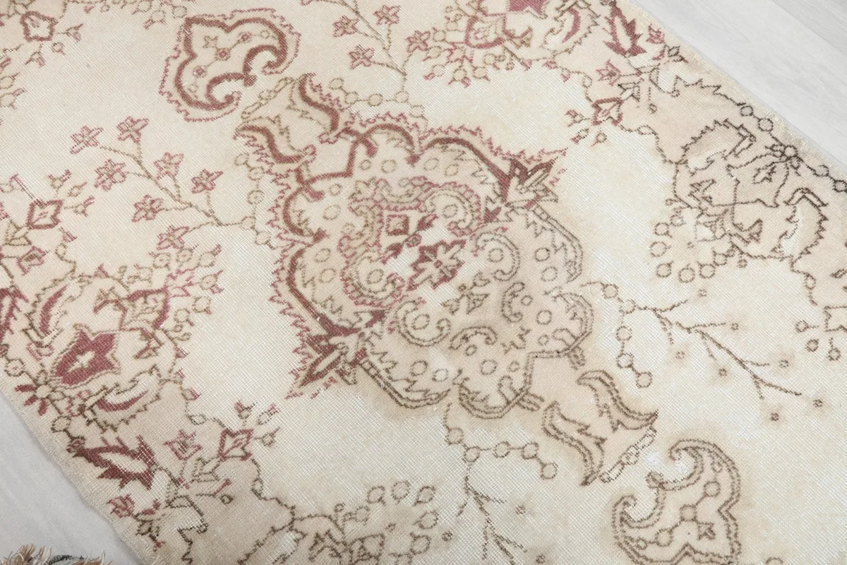 Close-up of the central medallion and botanical elements in rose and beige tones