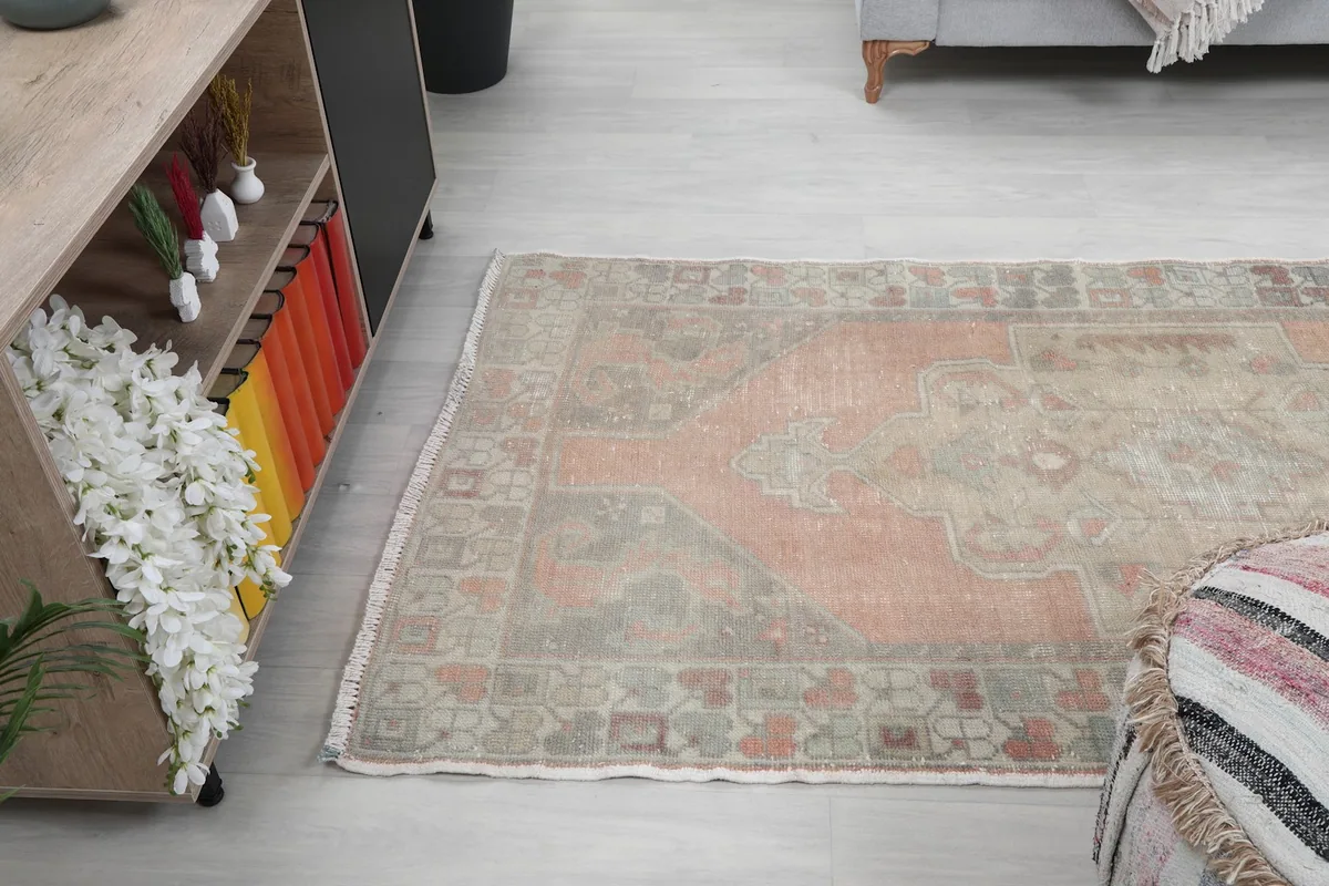 Angled shot of the rug on the floor, capturing its placement next to a console and ottoman