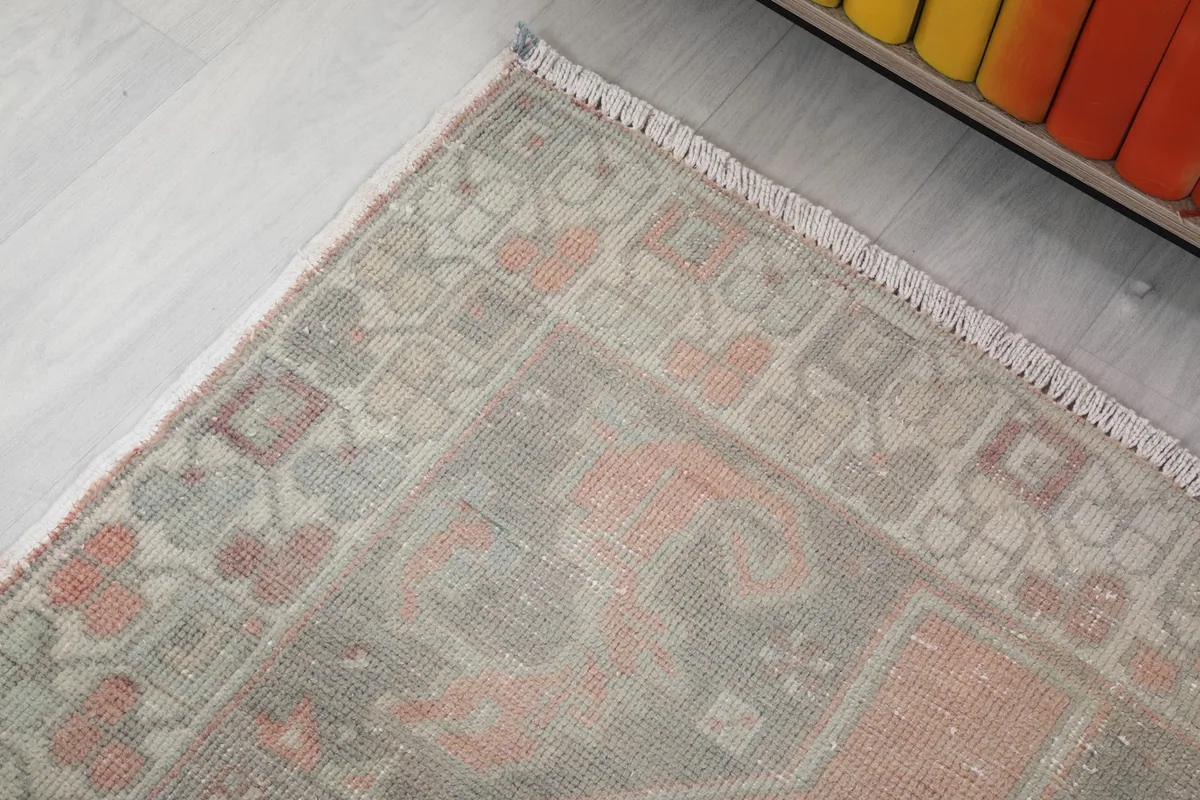 Corner detail of the rug, showing the fringe and intricate geometric patterns in the border