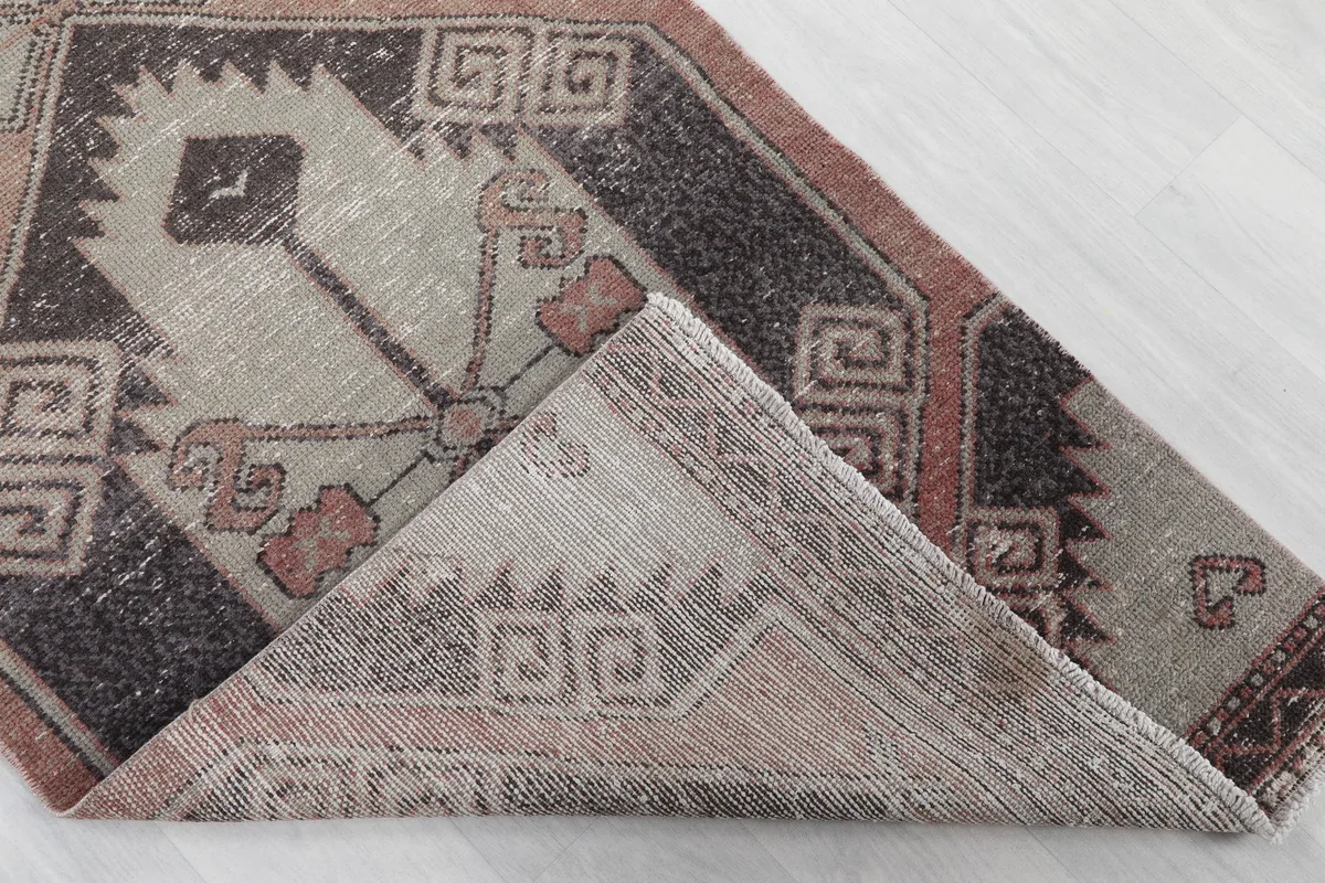 Corner of the runner folded back, revealing the hand-knotted cotton foundation and reverse side.