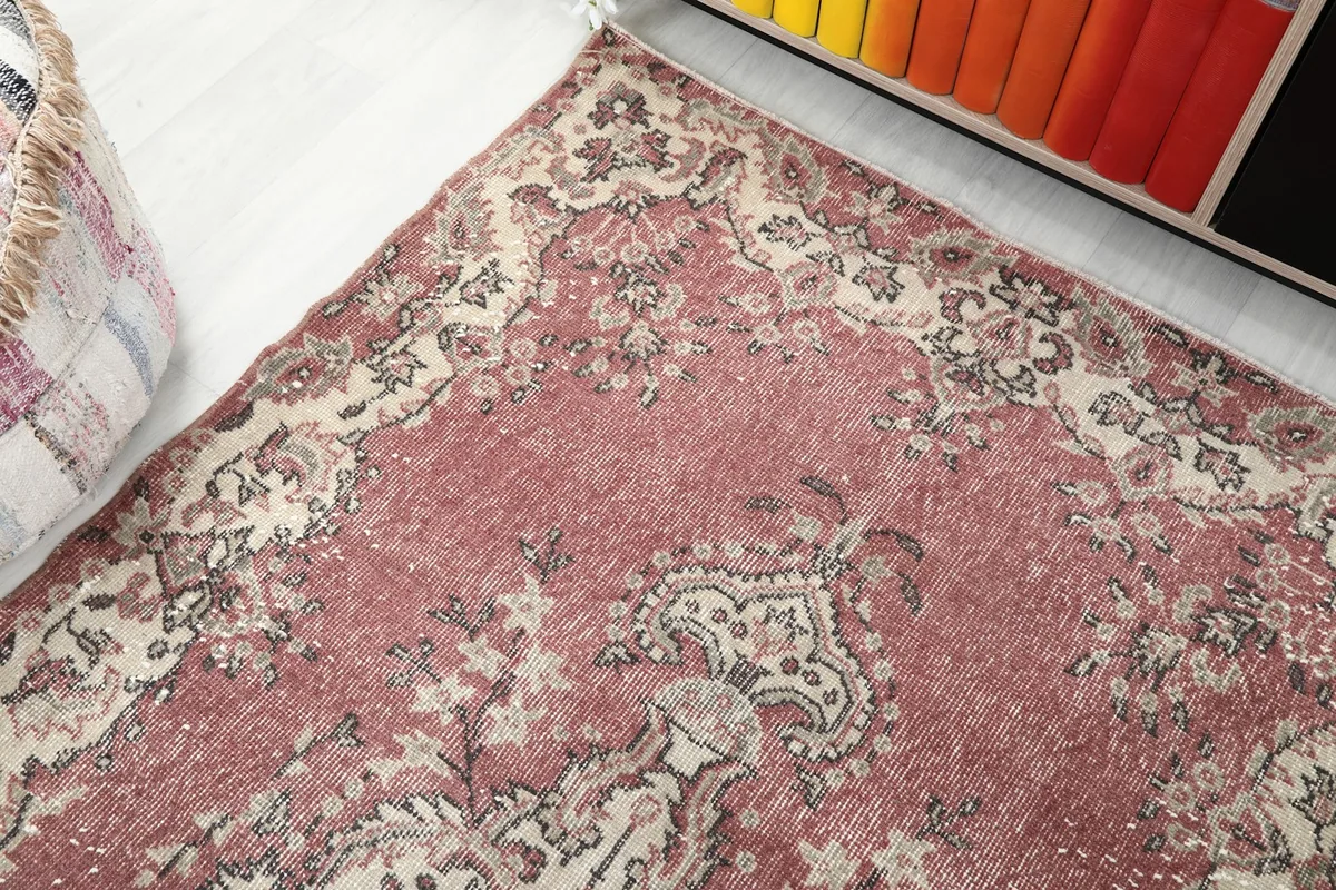 Angled view highlighting the distressed patina and color variations of the rug.