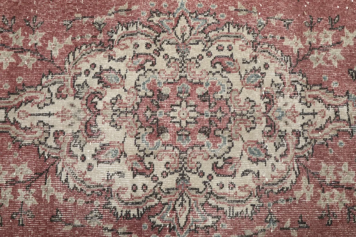 Close-up of the central medallion with rose, beige, and gray tones.