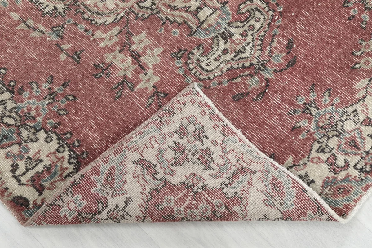 Folded corner of the rug revealing the tightly woven wool pile and cotton foundation.