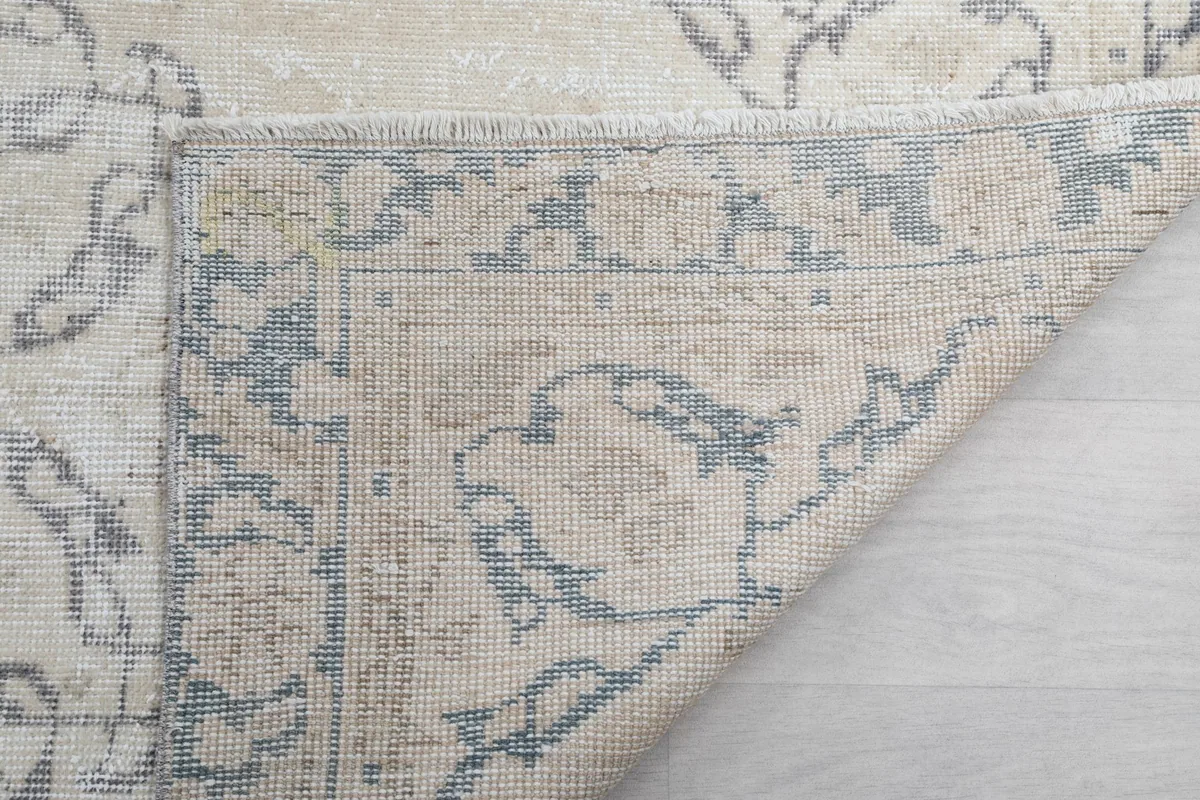 Detailed view of the rug's underside, showing the knotting and construction of the wool pile on cotton