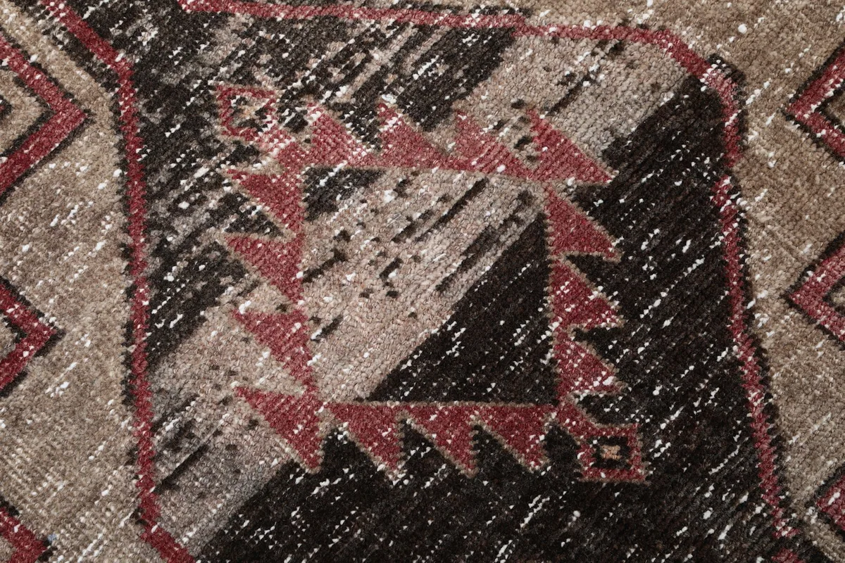 Texture detail of the low wool pile, showing the distressed look and hand-knotted quality.