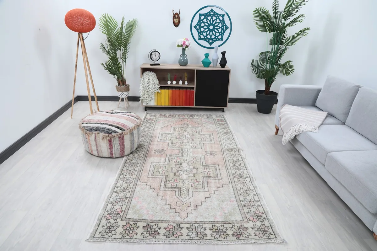 Vintage Anatolian area rug in a modern living room setting with a gray couch and wooden furniture.