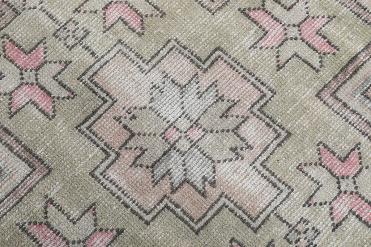 Texture of the low wool pile, showing the hand-knotted weave and vintage patina on the rug surface.