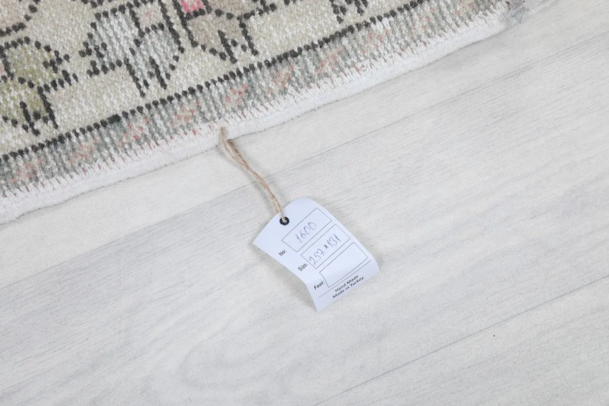 Product tag displaying the rug's size and origin, lying on the floor next to the rug.