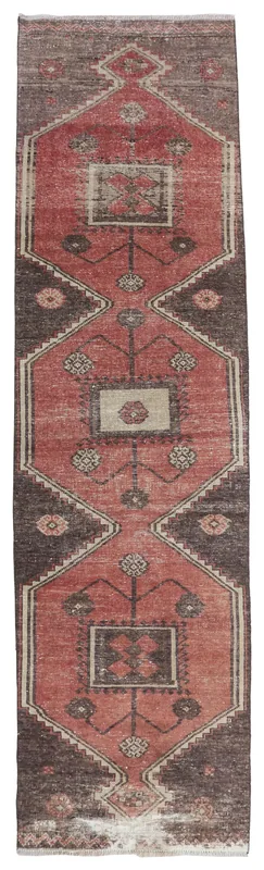 Full overhead view of the rust and brown geometric runner rug on a white background