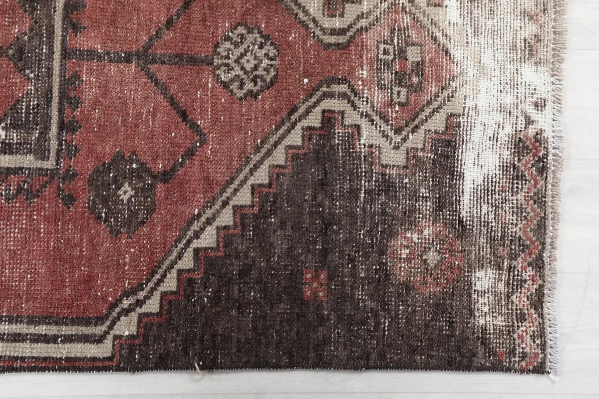 Close-up of the geometric pattern and border, showing wear and color variations