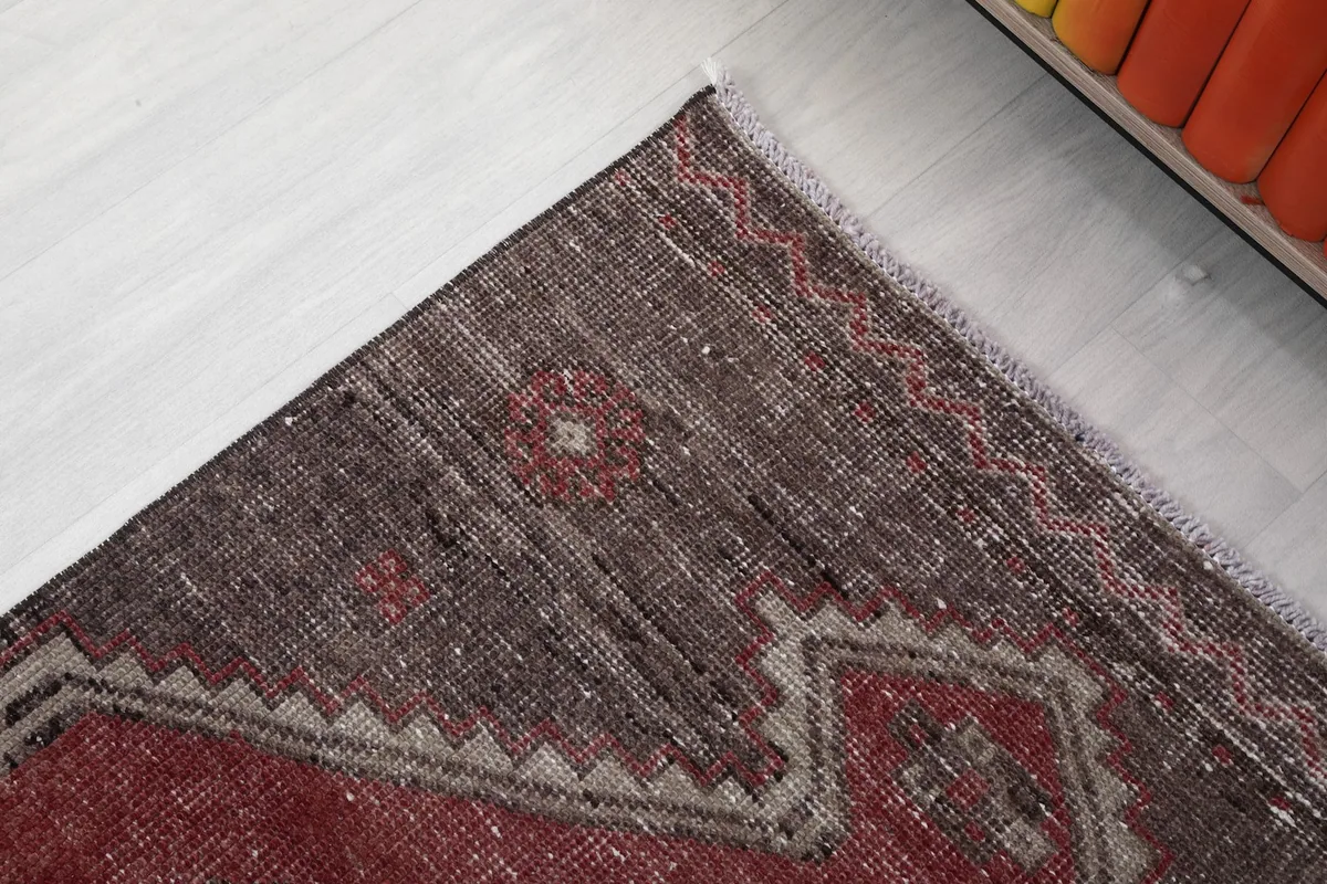 Detail of the rug's outer border and corner, highlighting the brown and beige patterns