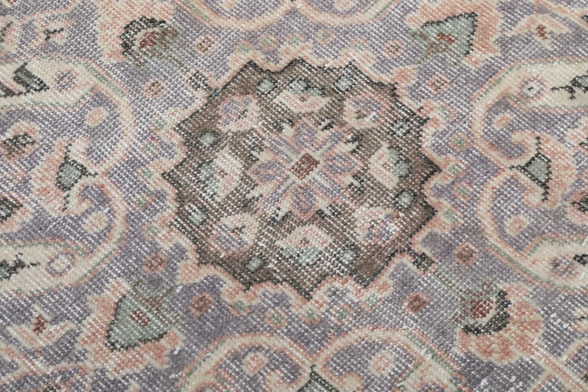 Extreme close-up of the central medallion's pattern, showing individual knots and wool texture.