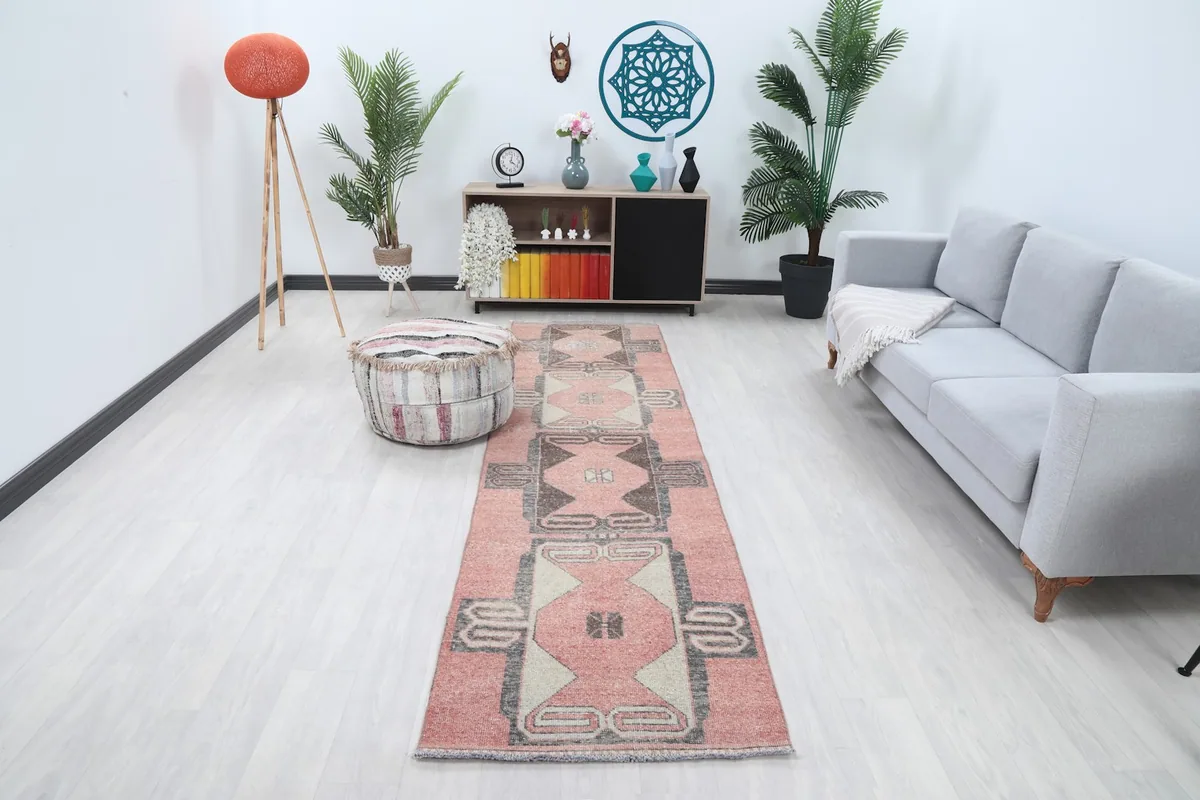 Vintage runner rug displaying rose and gray geometric patterns in a modern living space.