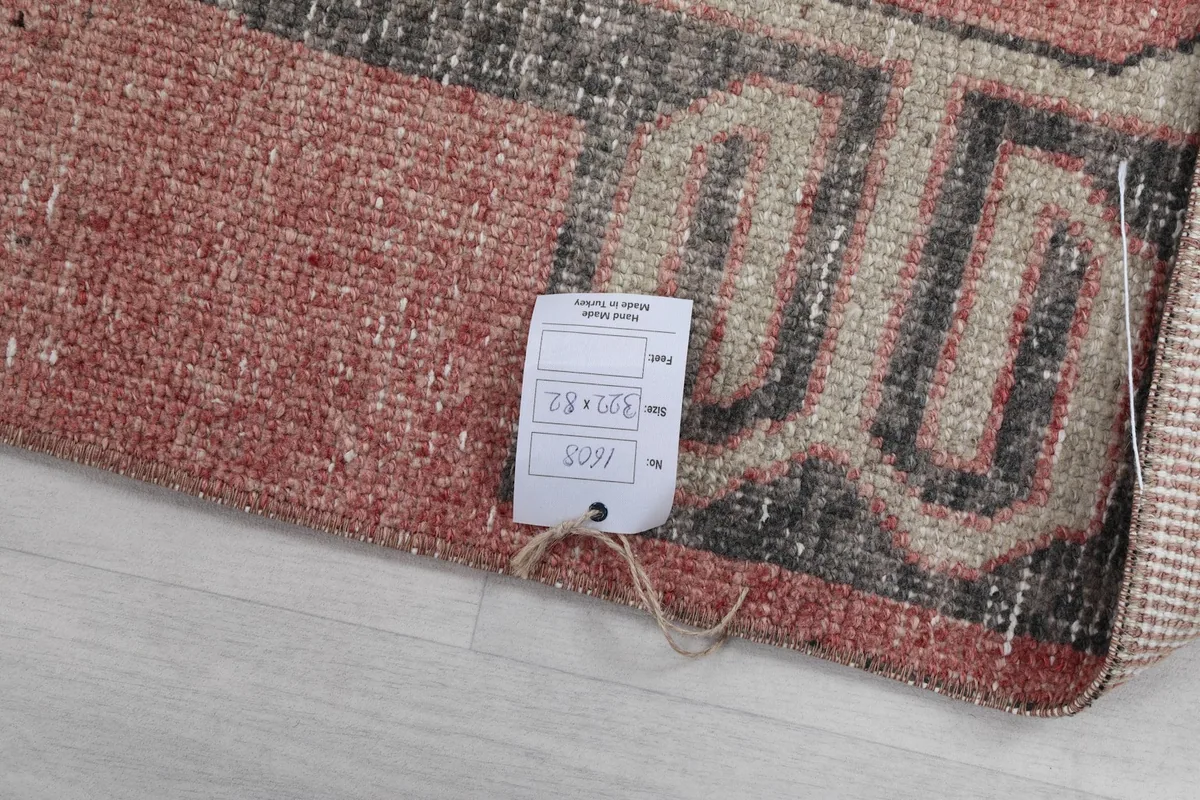 Close-up of the size tag attached to the rug, confirming its dimensions of 82 x 322 cm.