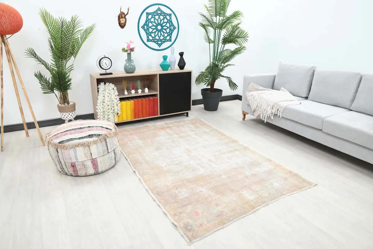Angled view of the beige and rose rug in a living space, showing its placement