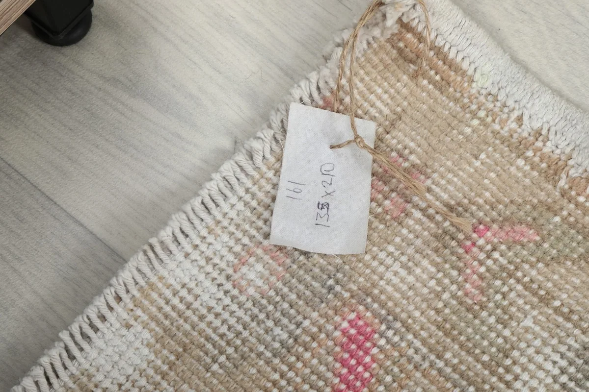 Close-up of the rug's reverse side showing the original size tag and hand-knotted construction