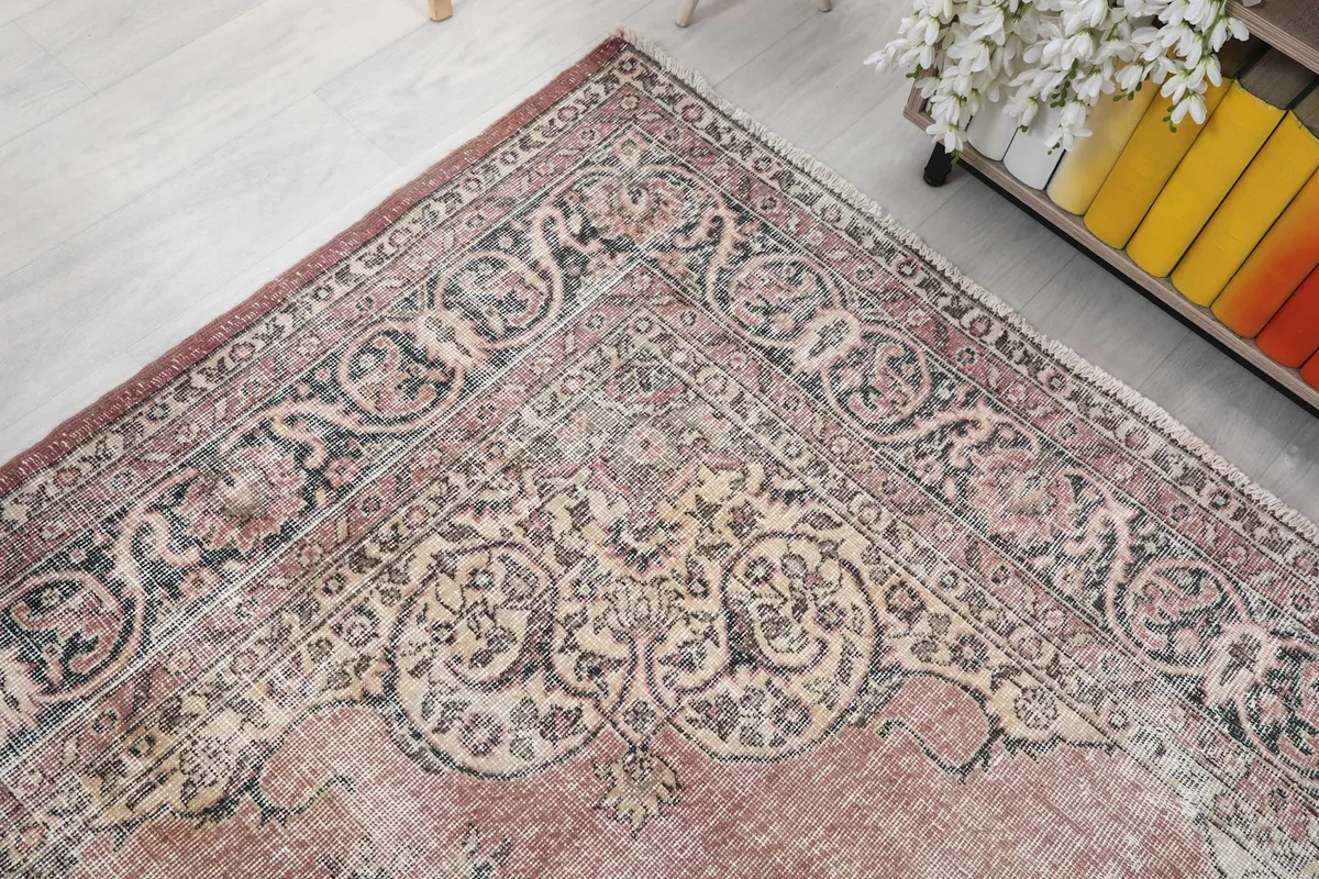 Corner detail of the rug's border and field, seen from an elevated angle in the room