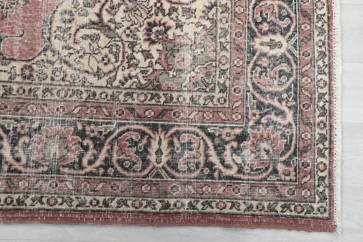 Detail of the corner and border design of the rose rug, highlighting black and ivory patterns