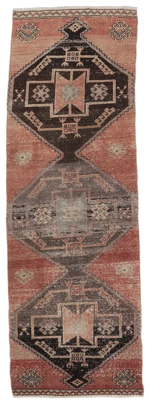 Full overhead view of the rust, black, and gray geometric vintage runner rug