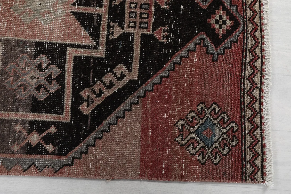 Detailed view of the rug's end section, showcasing the geometric patterns and border design