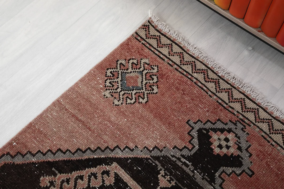 Detail of the rug's corner, highlighting the intricate geometric motifs and fringe