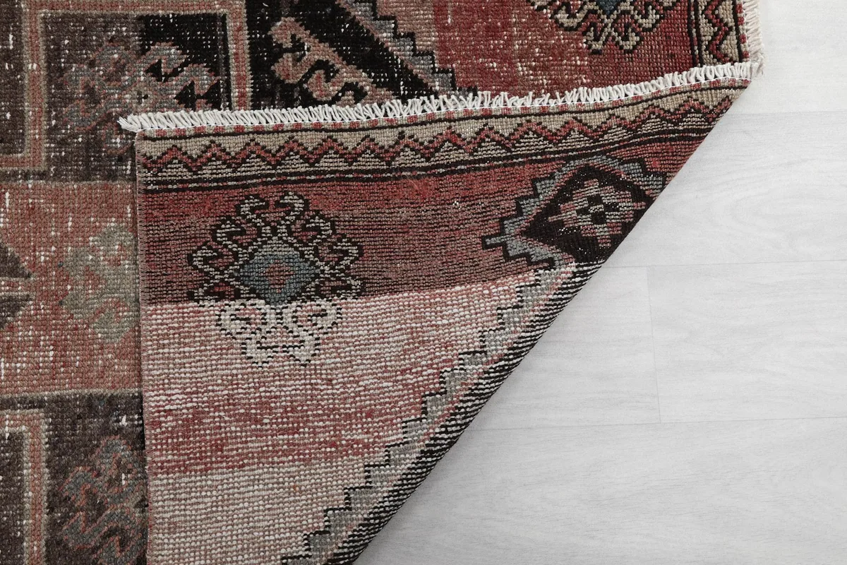Another view of the rug's corner folded, showing the reverse side and knotting detail