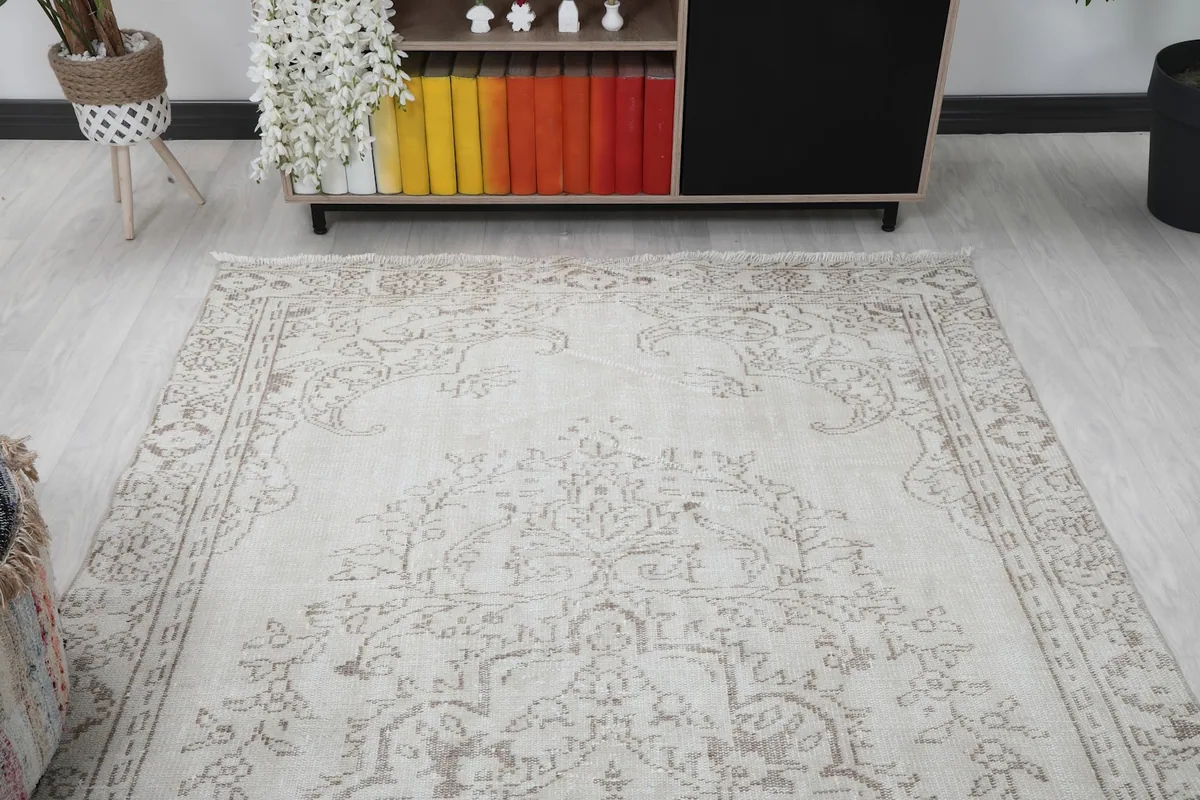 Overhead angled view of the rug, highlighting the soft ivory field and gray patterns