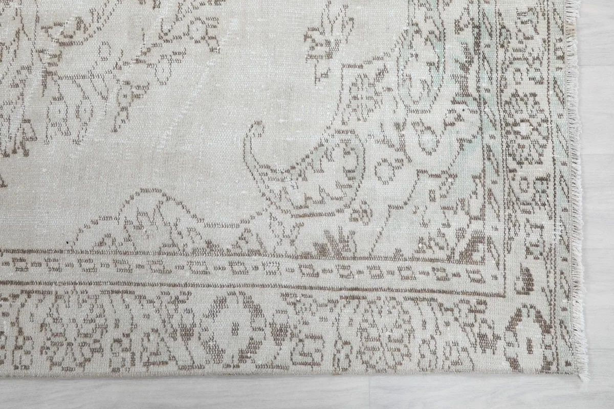 Detailed view of the corner motif and subtle border patterns of the rug