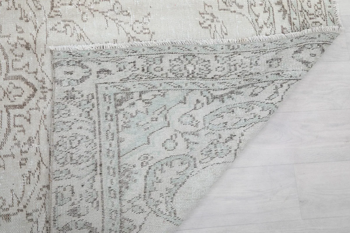 Close-up of the back of the rug and the intricate knotting, showing the fringe