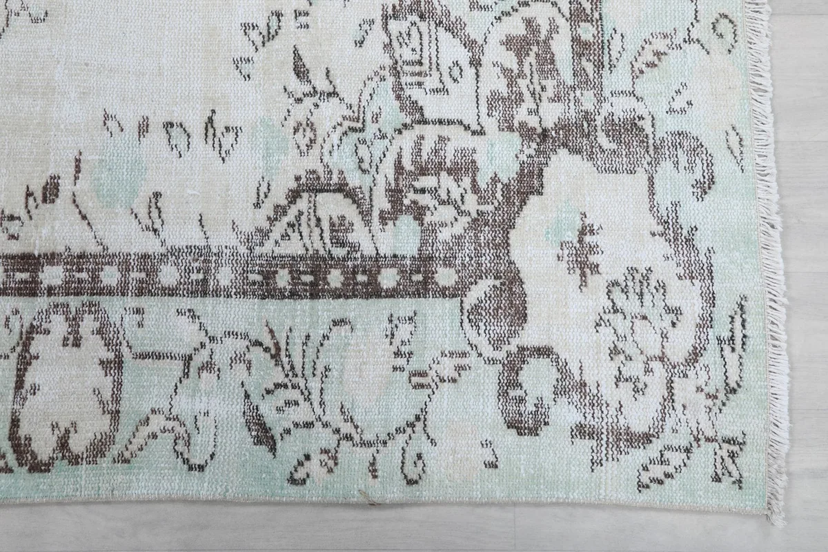 Detailed view of the corner motif and border design, showing green and brown colors