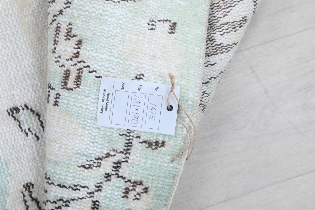 Tag on the rug showing product details and origin, partially rolled