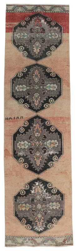 Full top view of the rose and charcoal geometric vintage Anatolian runner rug on a white background