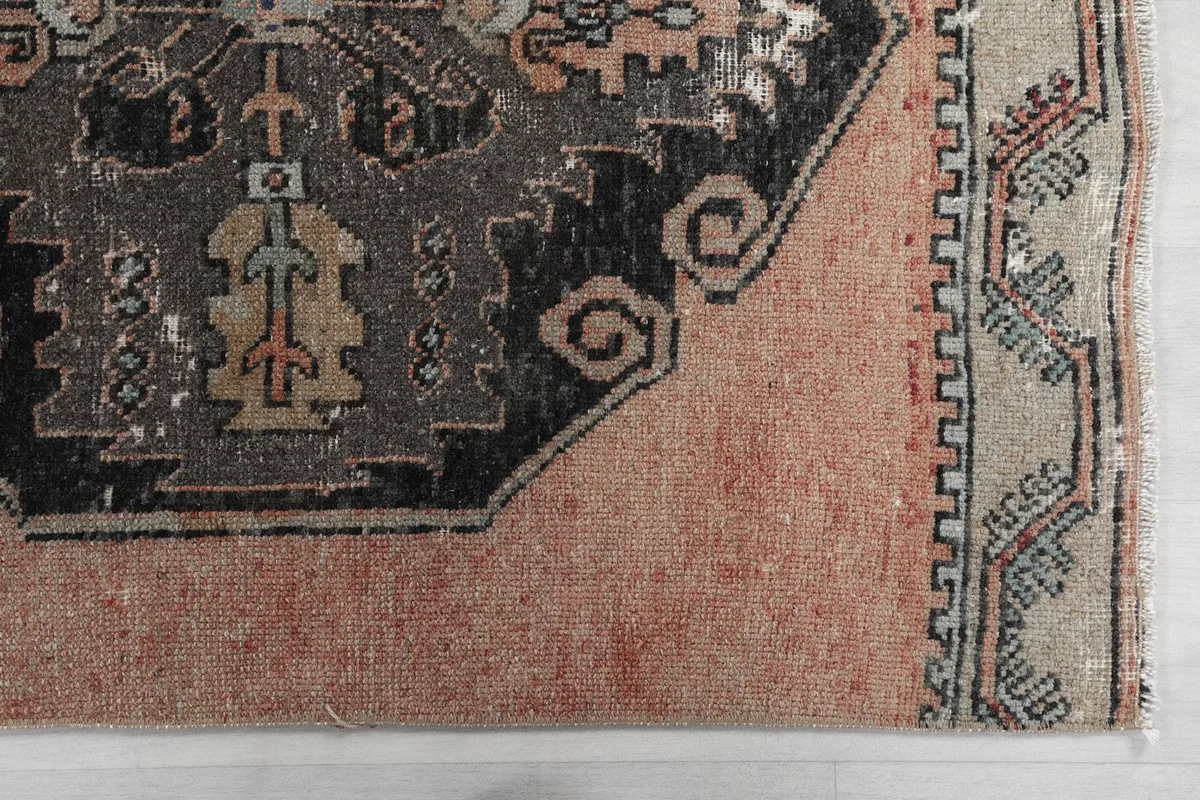 Detailed close-up of a corner of the rug, showing the border and part of a charcoal medallion