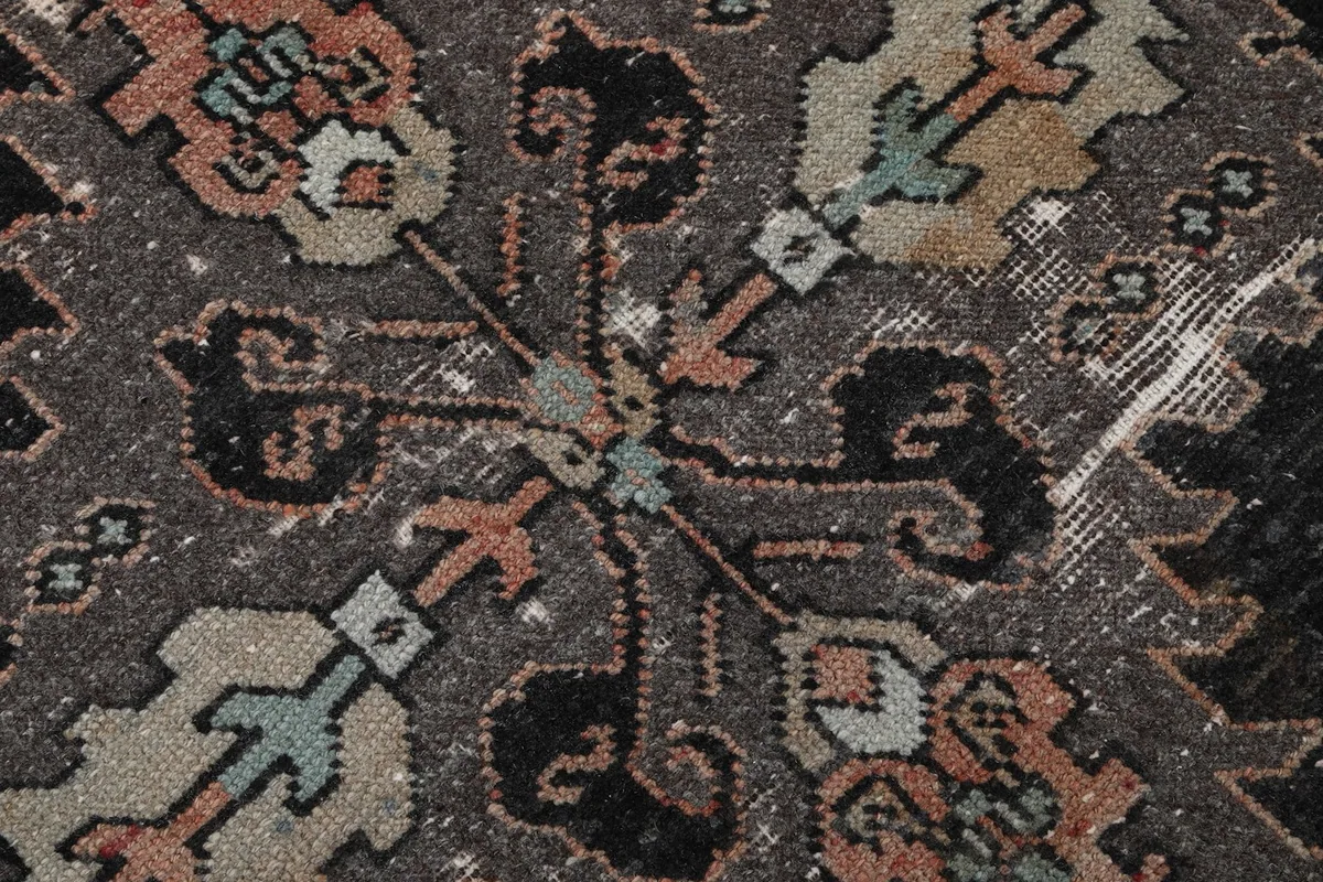 Extreme close-up of the rug pile, highlighting the distressed texture and intricate patterns