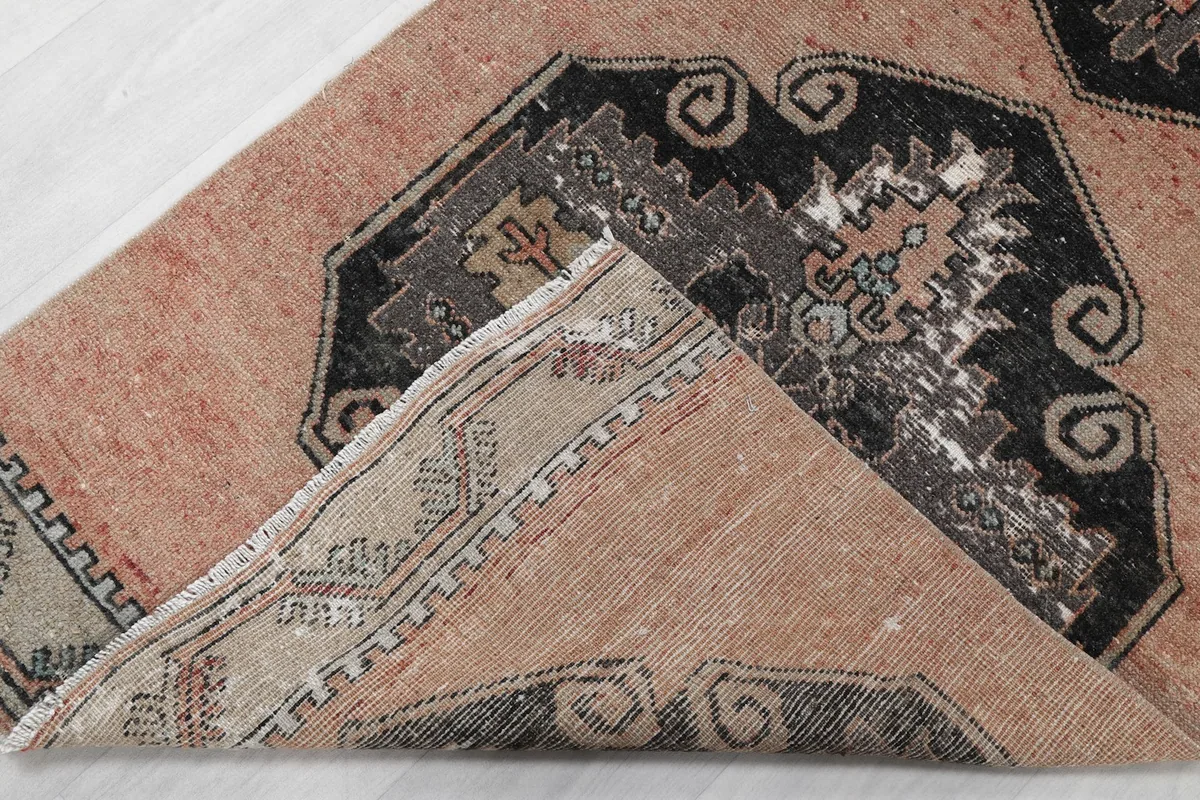 Close-up showing a corner of the rug folded over, revealing the cotton foundation and knotting