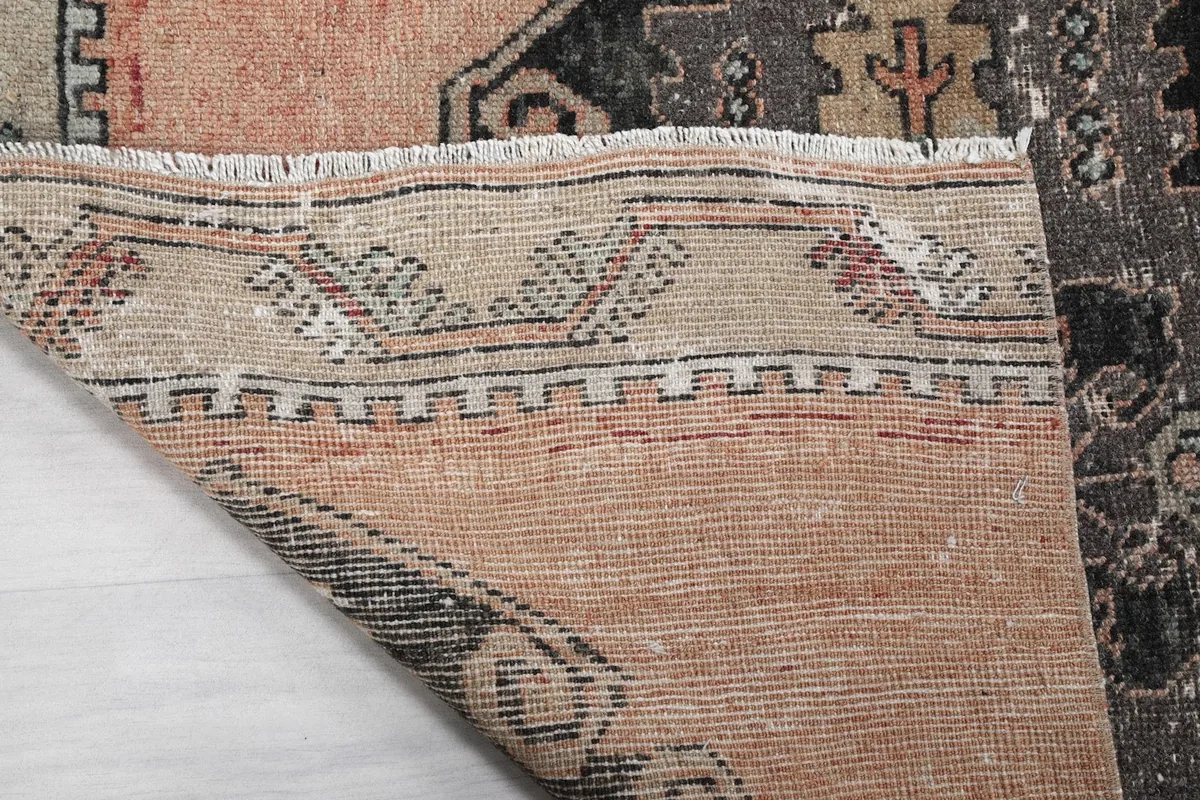 Close-up of the rug's edge, showing the hand-knotted wool pile and cotton foundation
