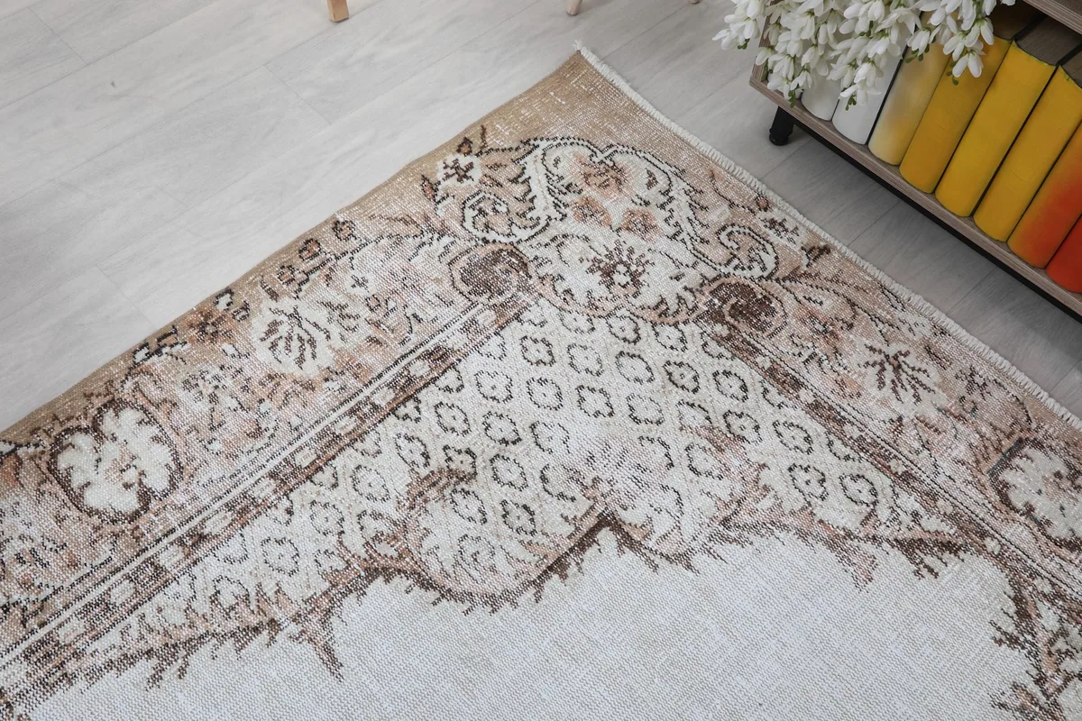 Detailed shot of an upper corner of the rug, showing the border pattern and the faded colors.