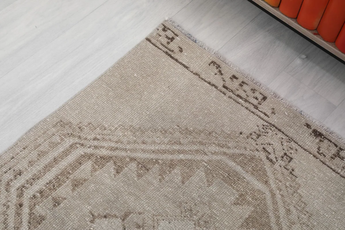 Corner detail of the runner rug, showing the geometric border pattern and gentle wear