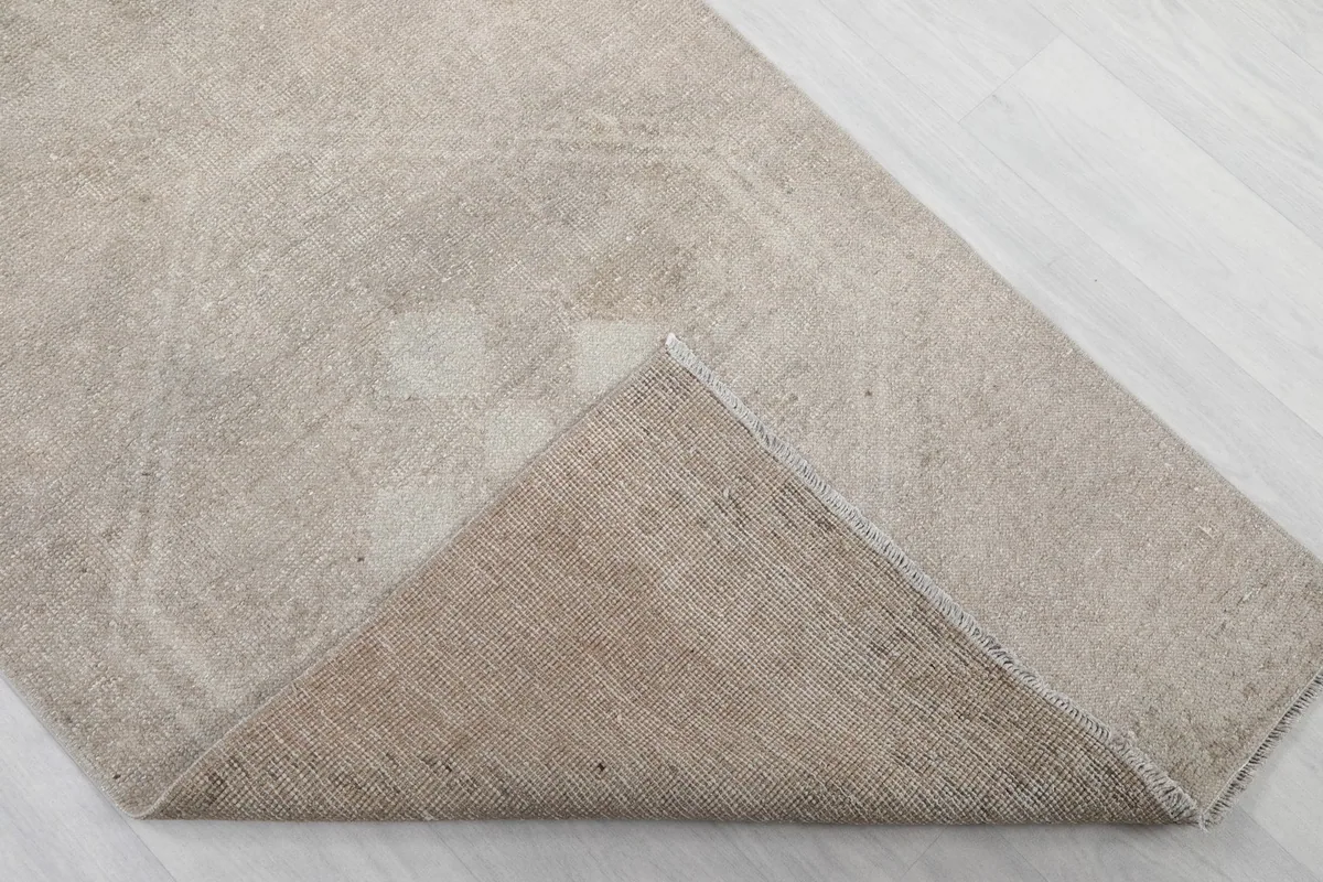 Folded corner of the rug, revealing the wool pile surface and cotton foundation