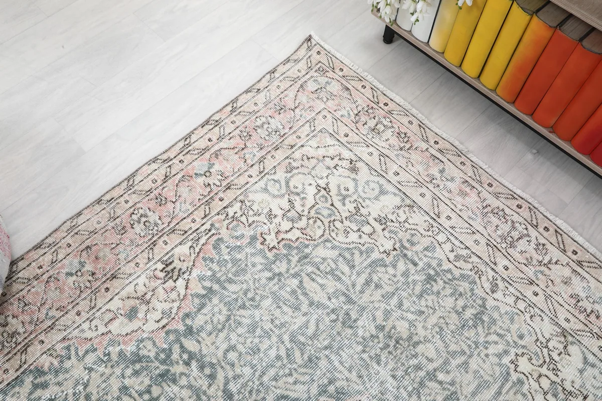 Corner view of the rug, illustrating the border design and faded blue field.