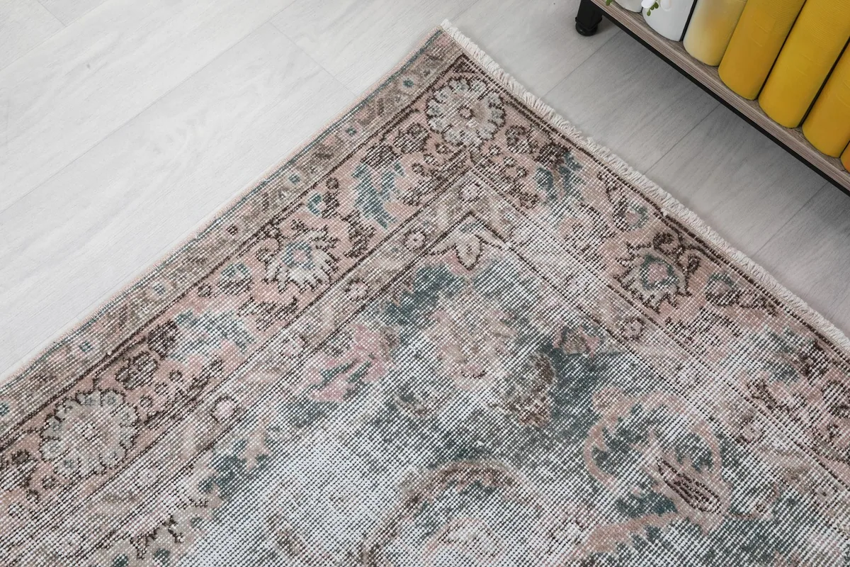 Detail of the corner border, displaying intricate floral and geometric motifs in rust and blue tones.