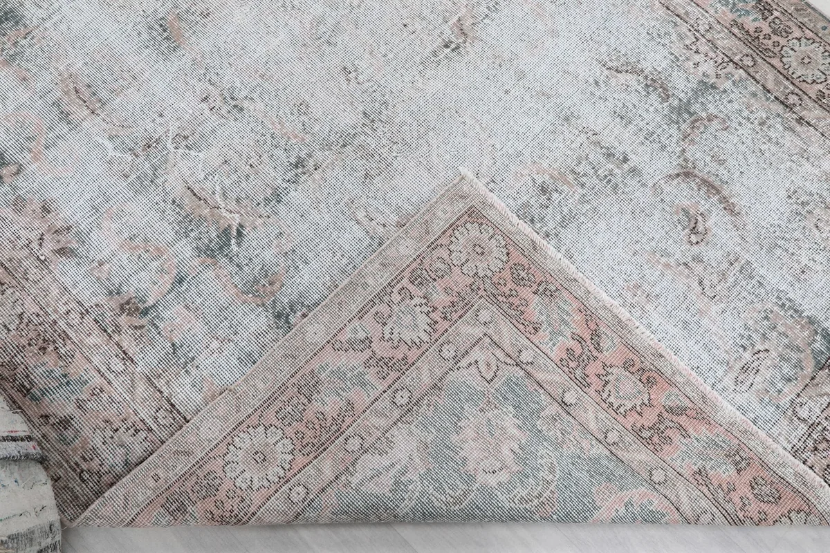 Folded corner of the rug, showing the back of the hand-knotted cotton foundation and wool pile.