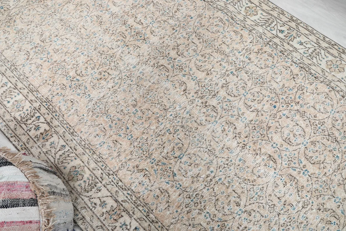 Overhead angle view of the beige and blue vintage Anatolian rug, showing texture and color variations